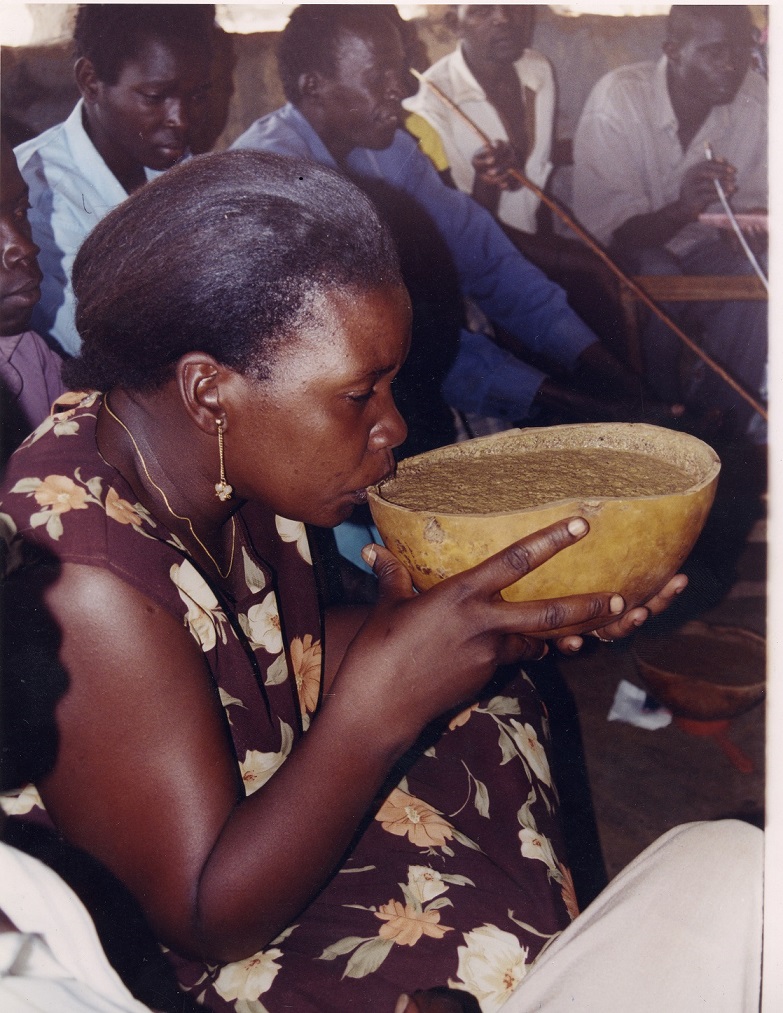 A lady sips on Malwa from a calabash called Adere in Teso