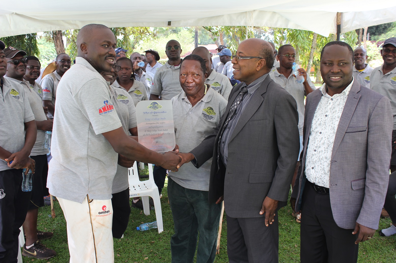 Charles Odaga Charles Odagaleft the President of the SMACK old boys association presents a plaque to Kings College Buddo Head teacher Patrick Bakka Male.jpg2