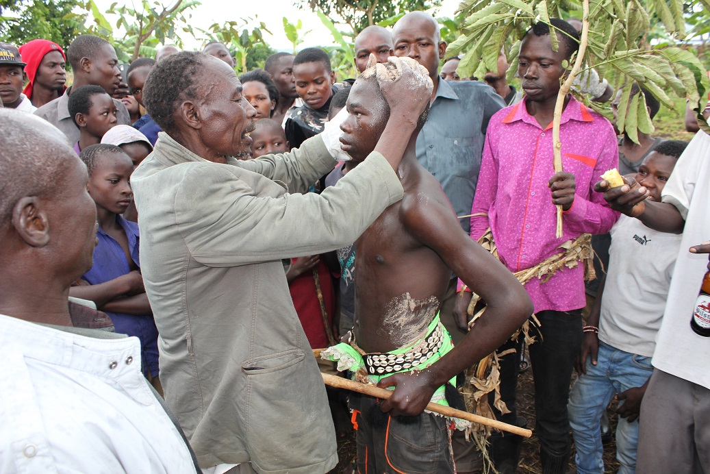 John Wamimbi an elder in Mutoto smears Watuwa his son with millet yeast