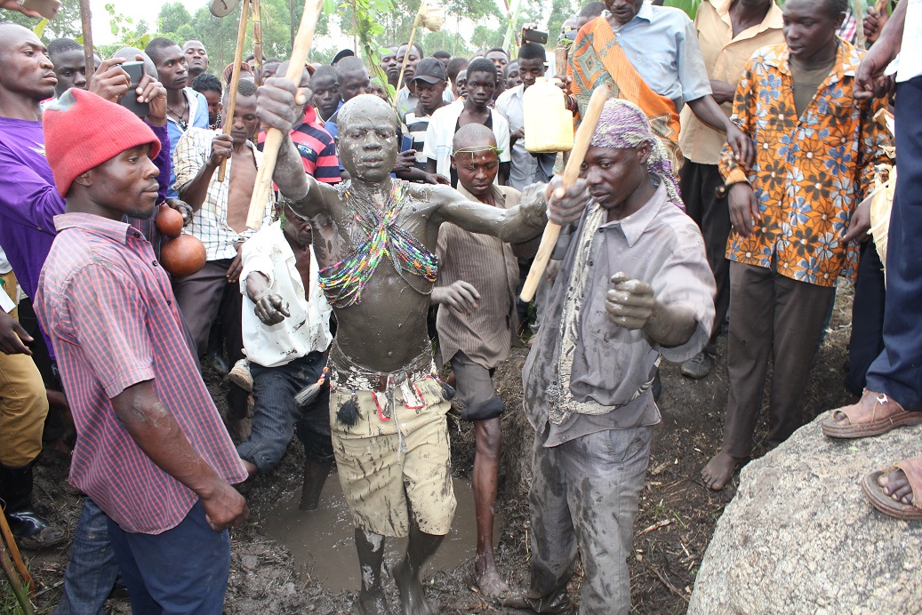 Khabeli is led away from the Black mud swamp after he had been smeared