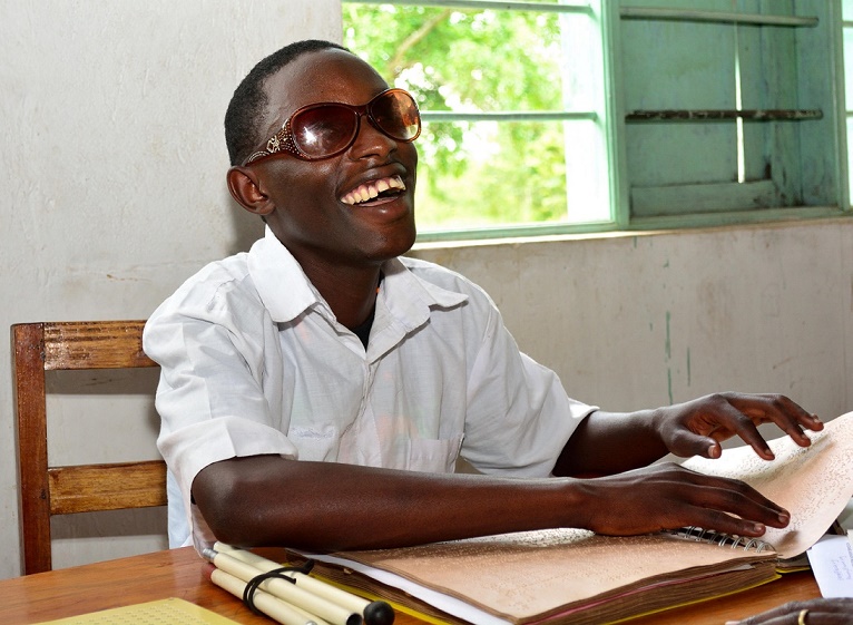 Masereka cheerfully reads Braille.1
